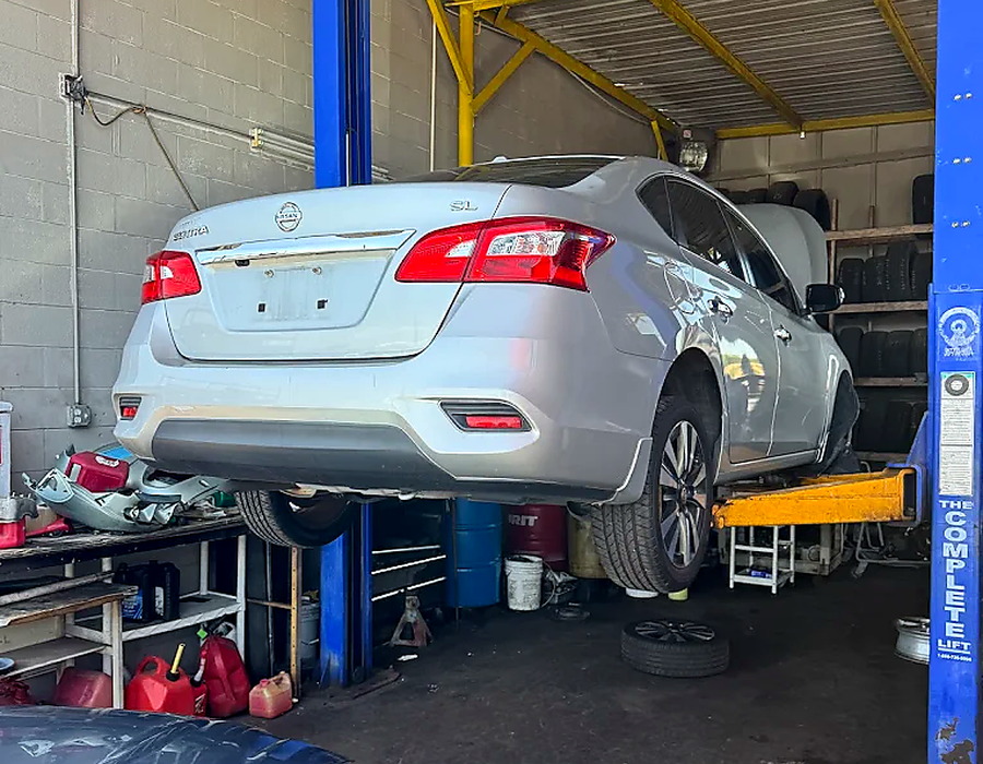 Vehicle on lift in Millan repair bay